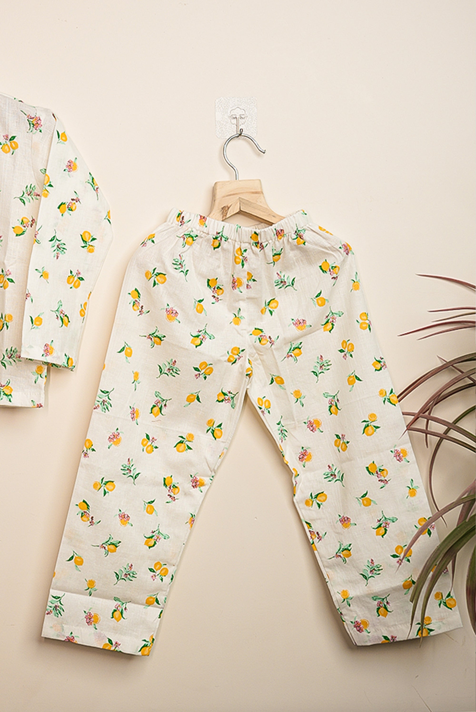 Floral-patterned pajama set hanging on a beige wall.