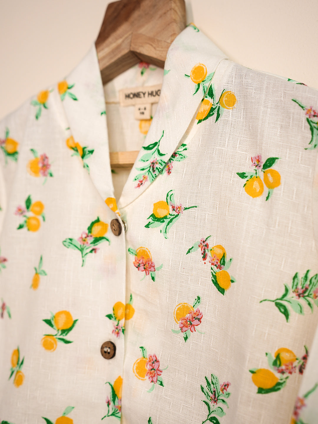 Floral and fruit patterned garment on a hanger