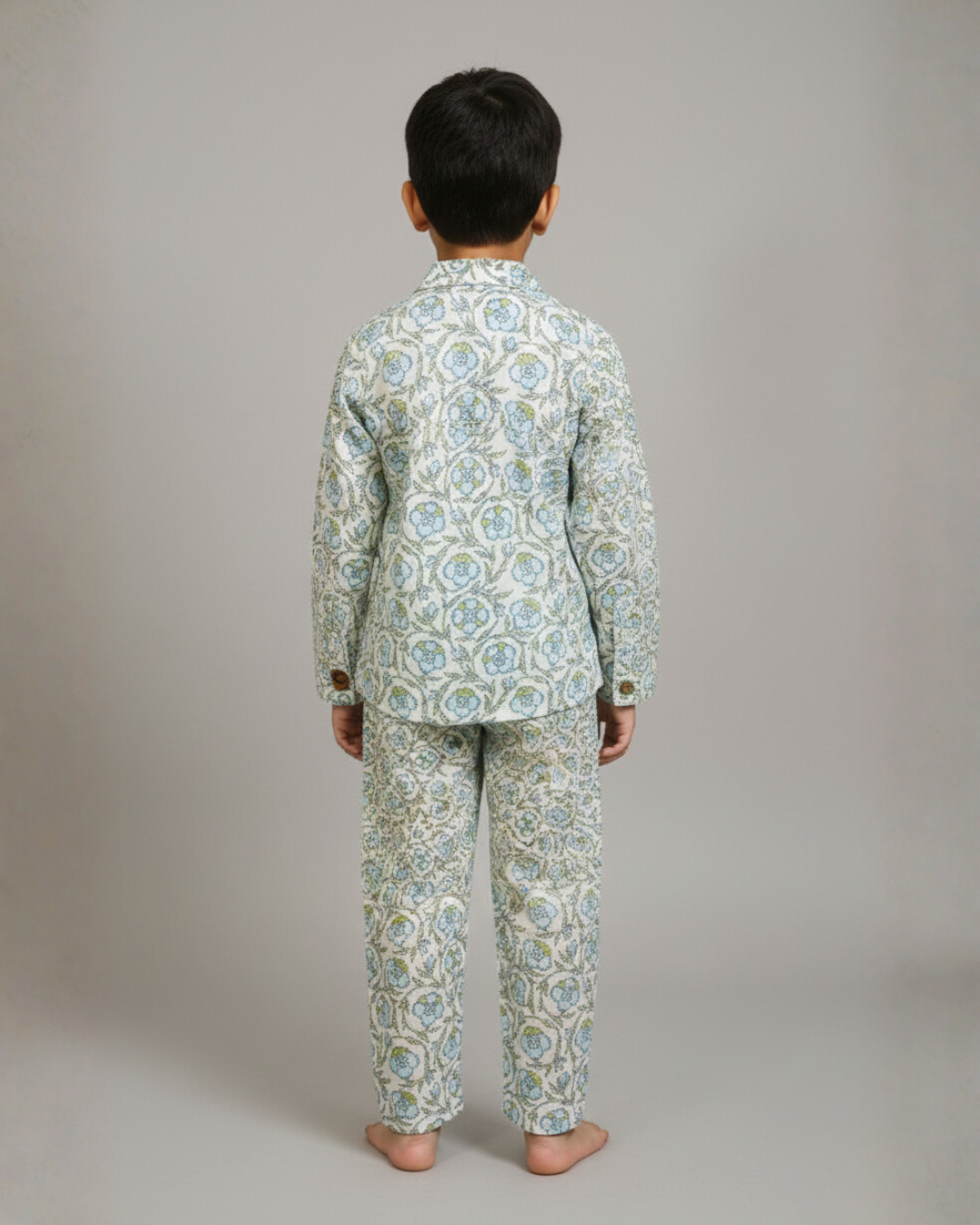 Child wearing a patterned pajama set on a plain background