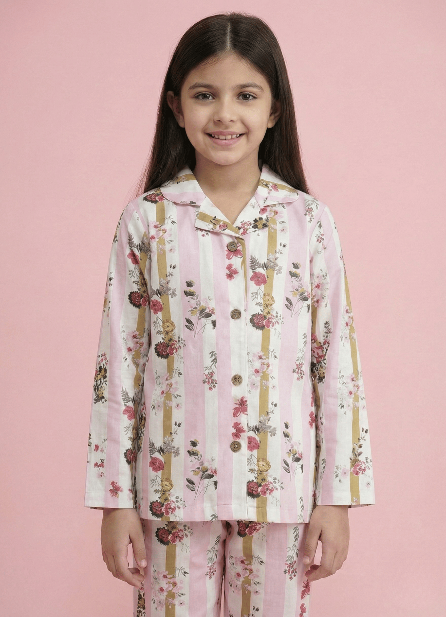 Young girl wearing a floral pajama set against a pink background
