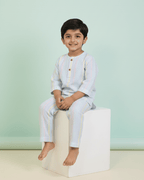 Child sitting on a white block against a light green background