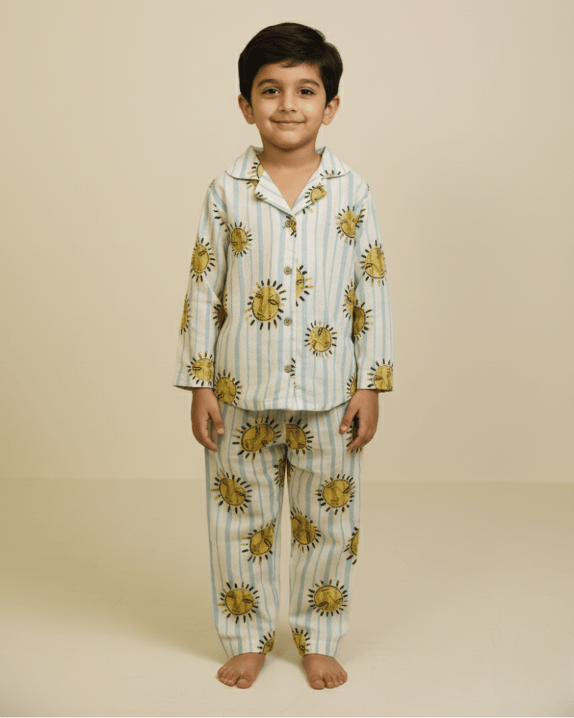 Child wearing a sun-patterned pajama set on a beige background
