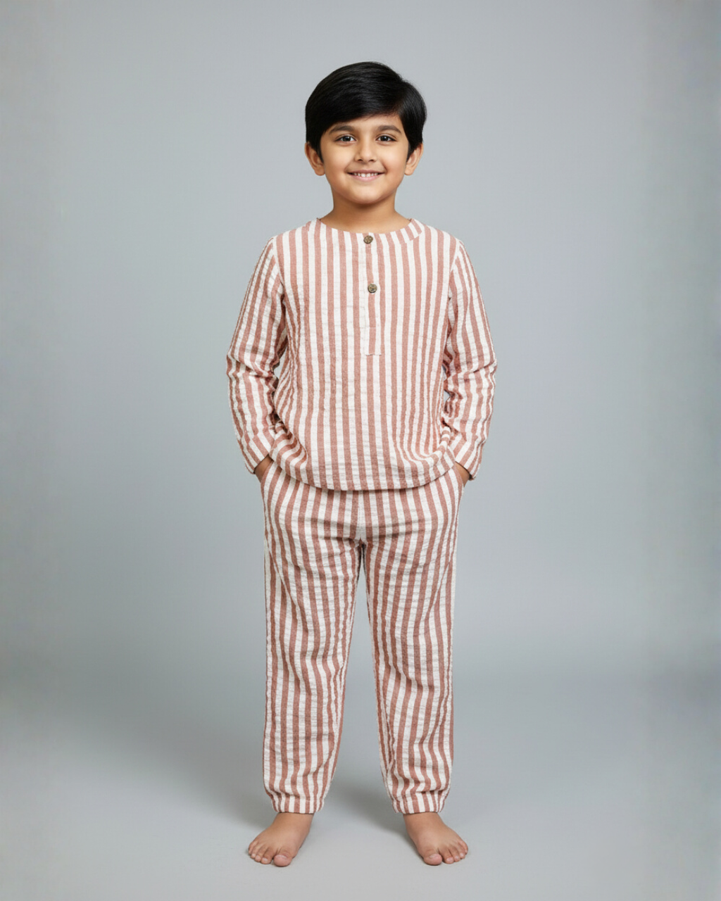 Child wearing a red and white striped pajama set on a gray background