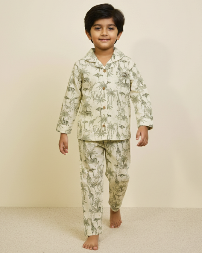 Boy walking barefoot in full-sleeve printed cotton pajamas against a simple background.